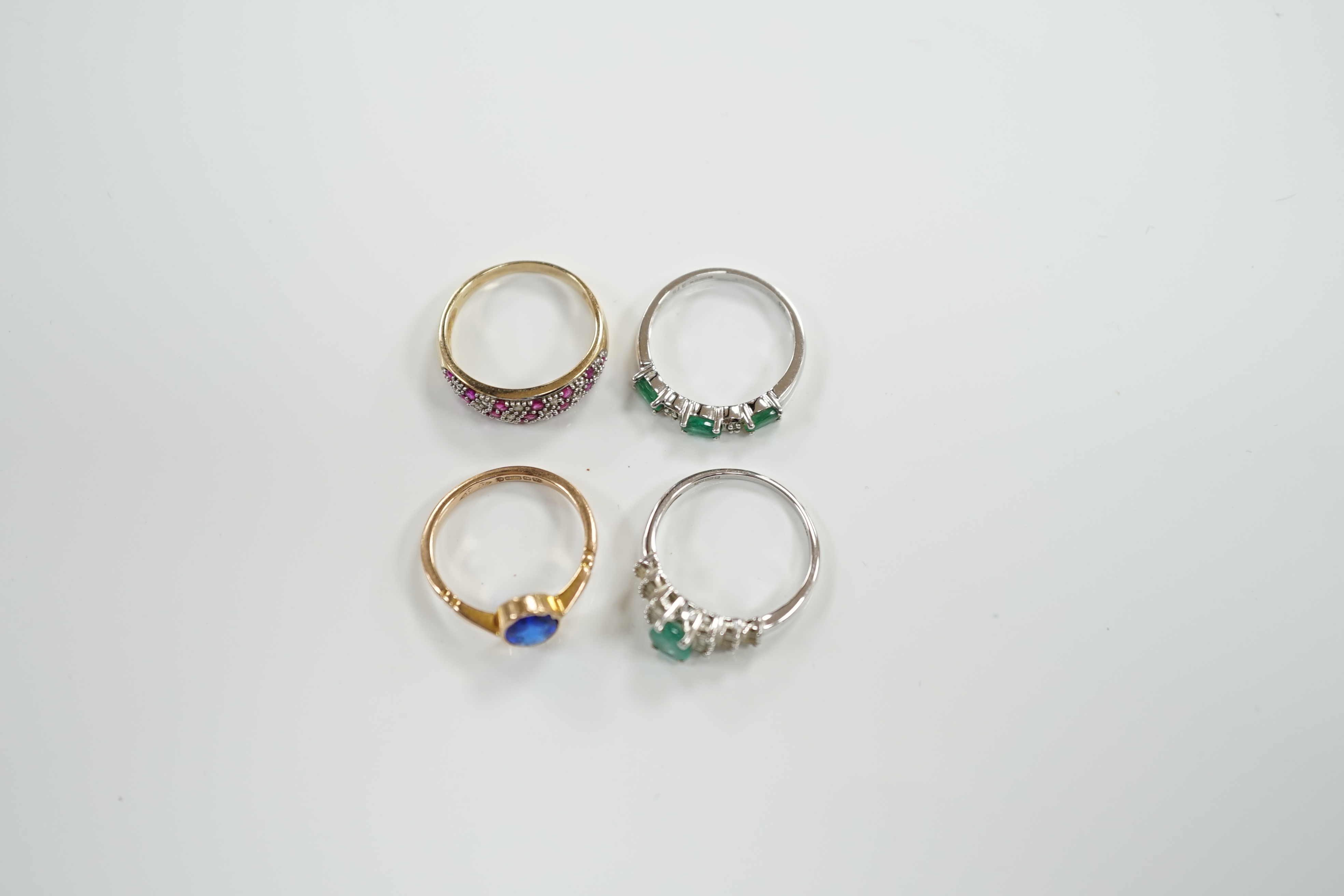 Three assorted modern 9ct gold and gem set rings including emerald and diamond chip set half hoop, size N, gross weight 6.8 grams and a modern14ct white gold and single stone emerald set dress ring, with baguette cut dia